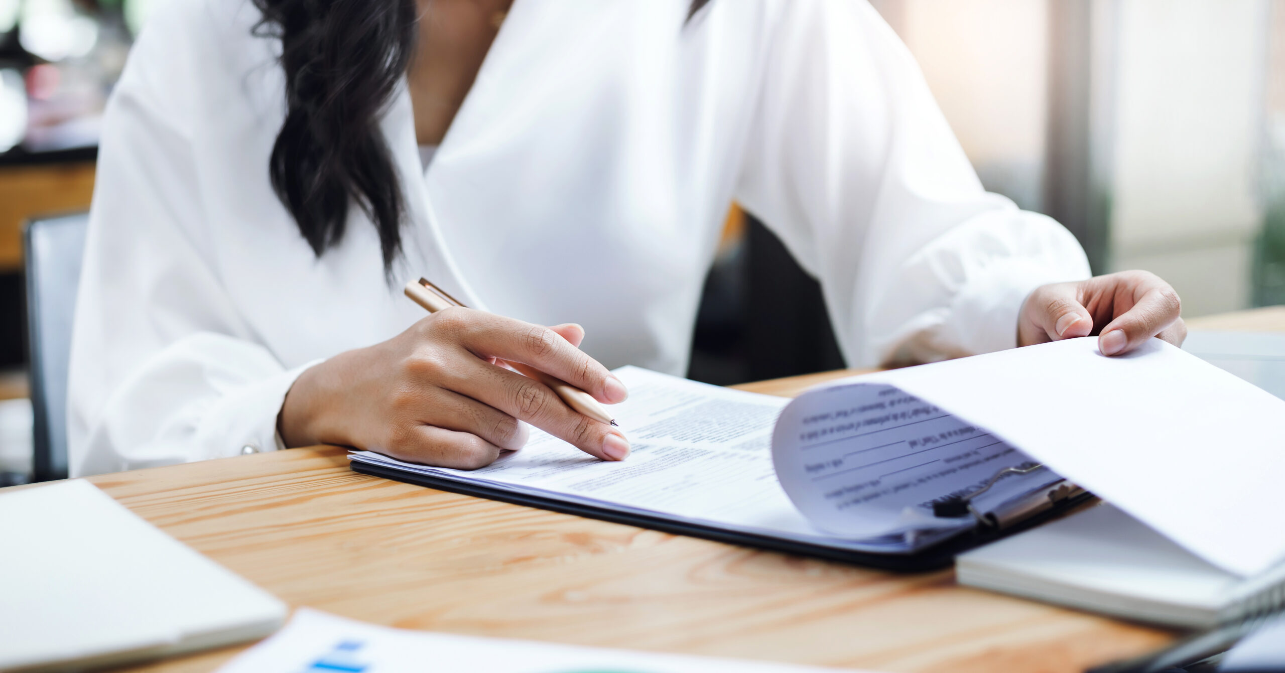 Asian businesswoman reviewing business contracts or life insurance contract for the benefit of her in the future or business person sign documents and get a loan to start new business