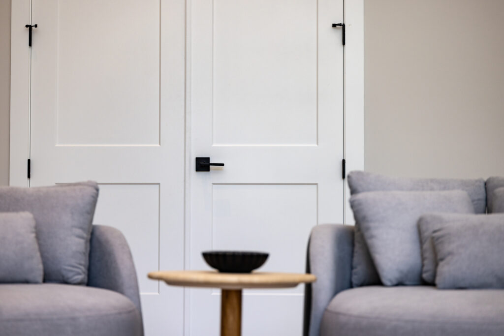 Modern living room with double white interior doors featuring black hardware, installed by 1st Choice Door & Millwork.