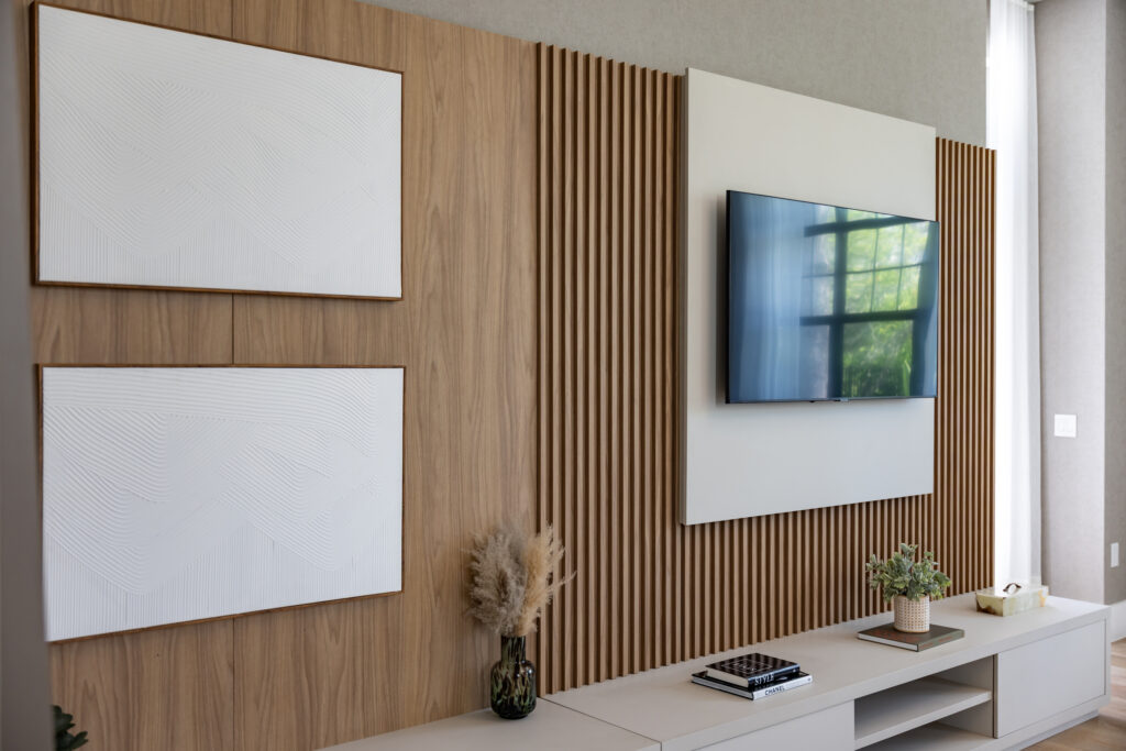 Sleek media wall featuring natural wood slats, floating cabinetry, and mounted TV — interior millwork completed by 1st Choice Door & Millwork.