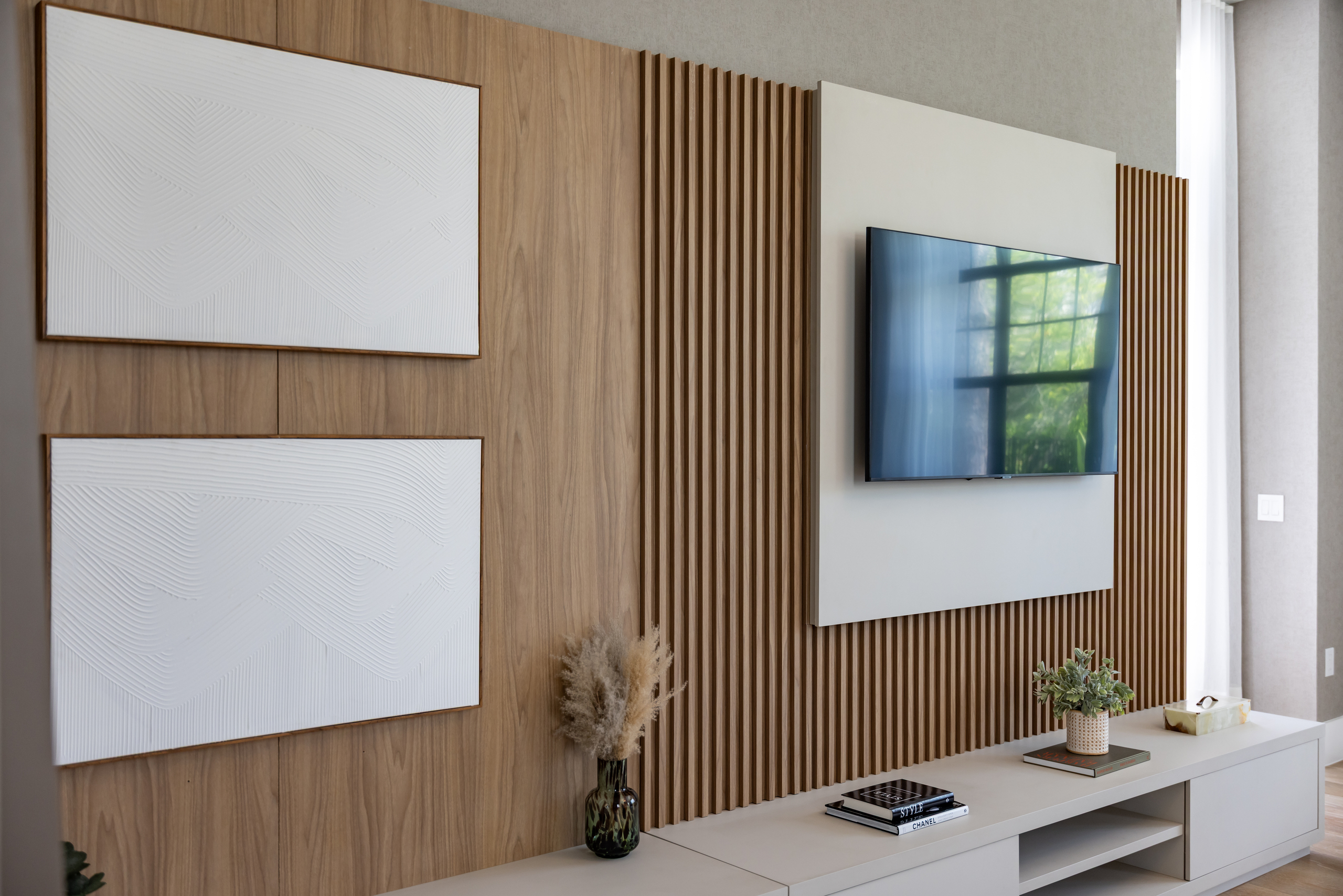 Sleek media wall featuring natural wood slats, floating cabinetry, and mounted TV — interior millwork completed by 1st Choice Door & Millwork.