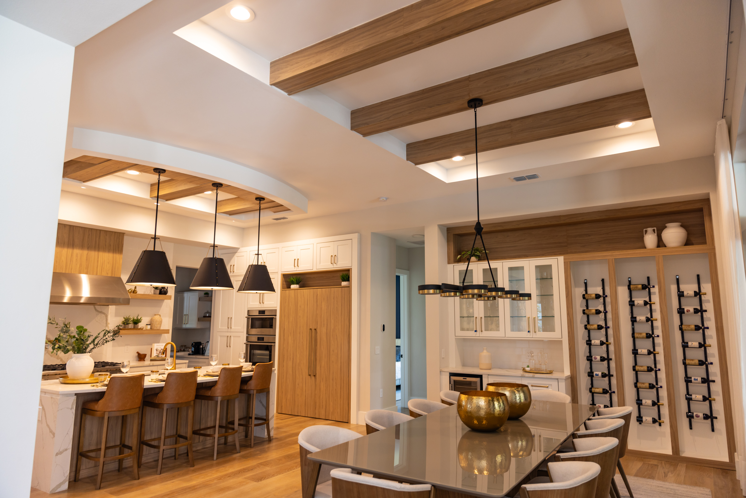Luxury kitchen and dining space featuring wood-accented ceiling beams, custom millwork, and modern lighting installed by 1st Choice Door & Millwork.