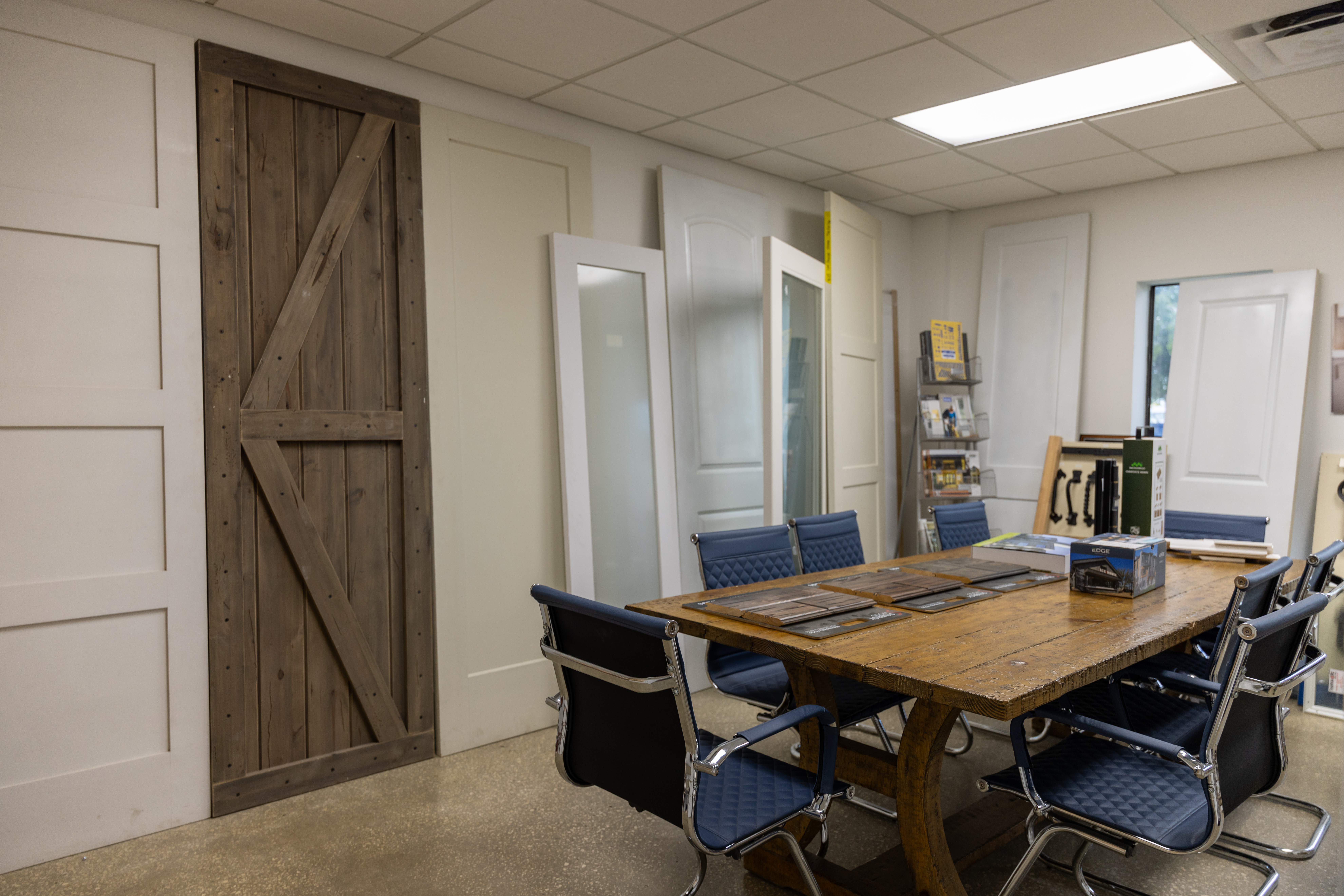 1st Choice Door & Millwork showroom meeting area with a table and chairs, surrounded by interior door display samples.