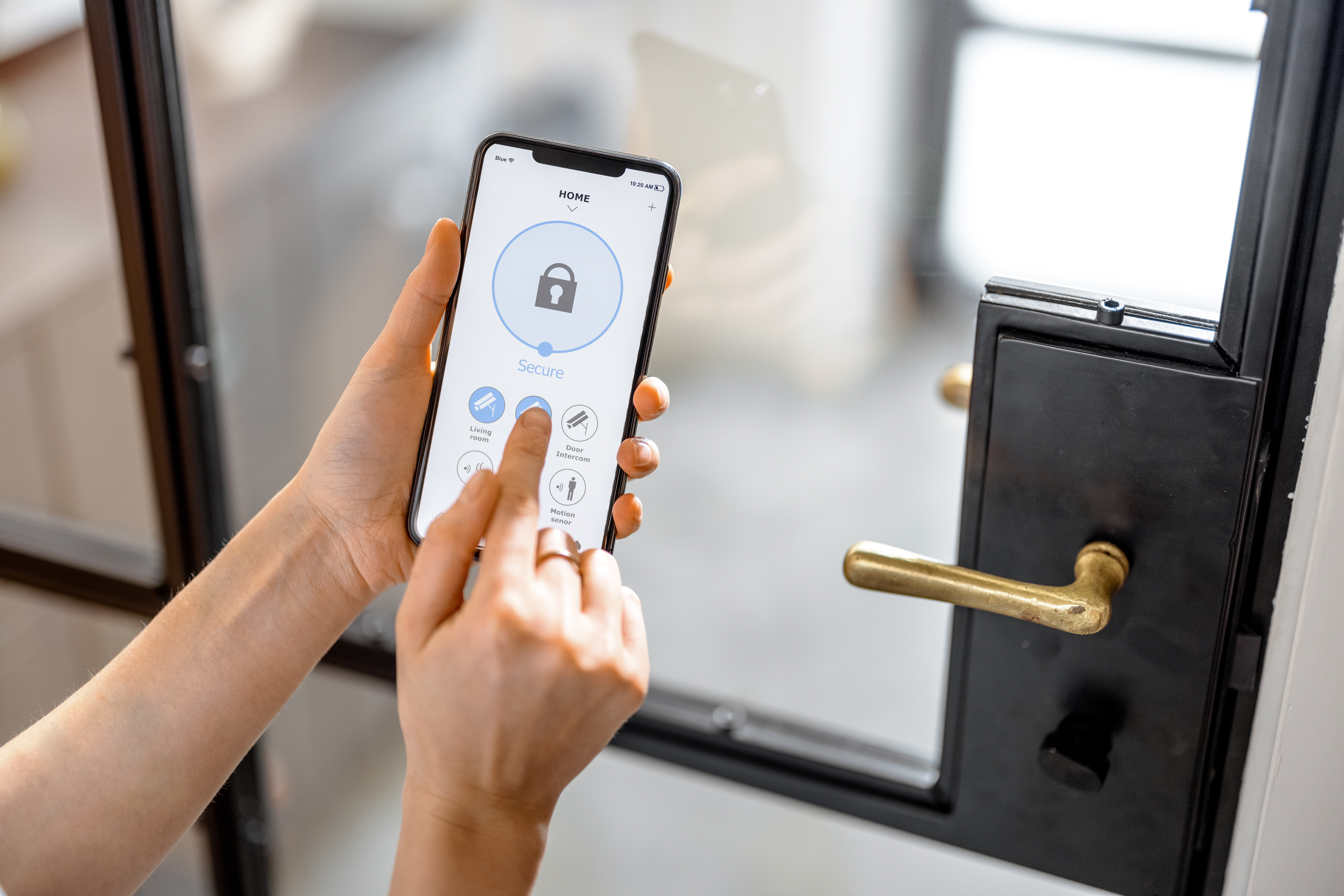 A Homeowner’s Guide to Smart Locks and Electronic Door Hardware 1 Person using a smartphone to control a smart door lock.